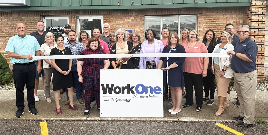 Krystal Levi (C), president and CEO of the Northern Indiana Workforce Board, cuts the ribbon during the ribbon-cutting ceremony Thursday for WorkOne’s new location at 3113 E. Center St., Warsaw. She is surrounded by WorkOne and Kosciusko Chamber of Commerce staff and Chamber ambassadors. Photo by David Slone, Times-Union