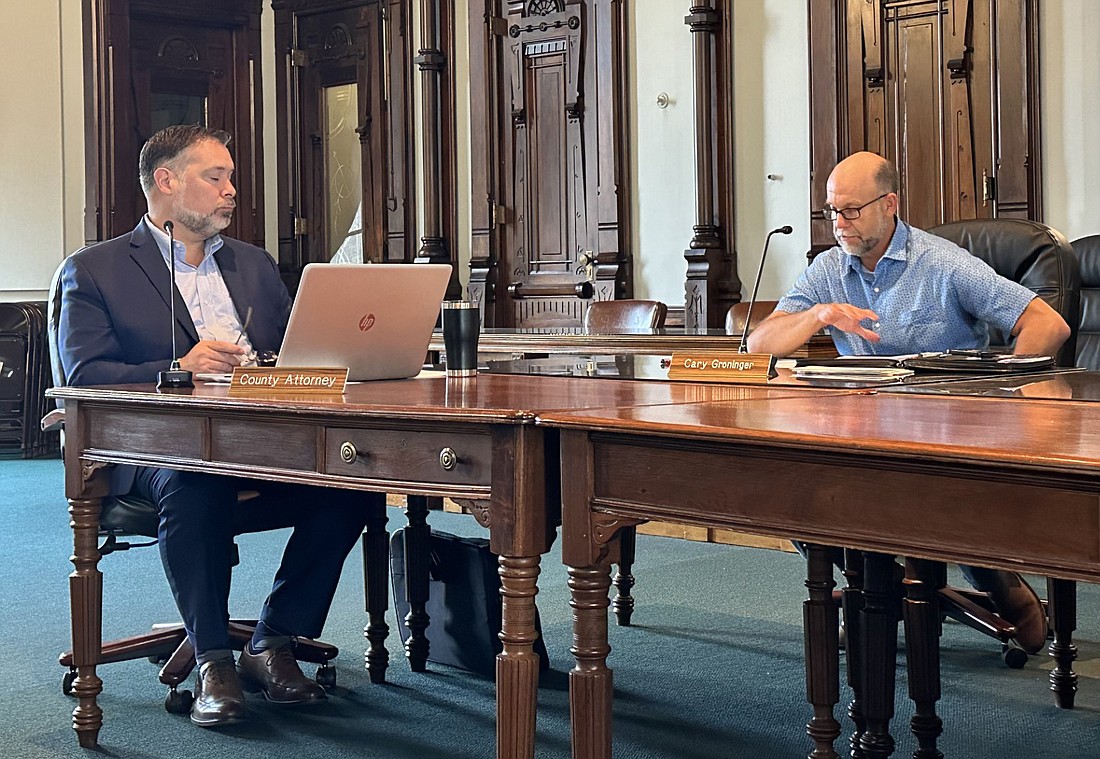 County Attorney Ed Ormsby (L) listens as Commissioner Cary Groninger (R) discusses the health funding provided by the state. Photo by David Slone, Times-Union