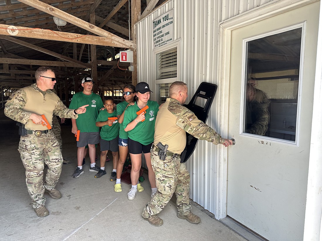 James Marshall (L) and Ryan Reed (R), Kosciusko County Sheriff’s Office SWAT, teach kids during Camp HERO on Friday how they enter a room when serving a warrant or apprehending a suspect. Photo by David Slone, Times-Union