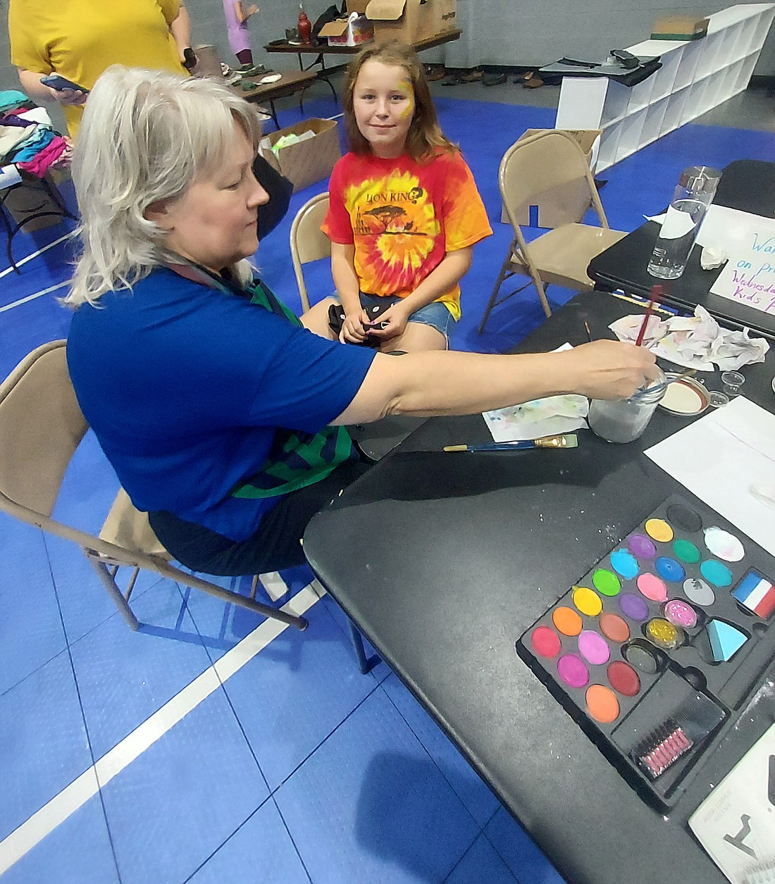 Olivia Dolbee gets her face painted by Karmin Wieland at LifeTouch’s ungarage sale Saturday. Photo by Jackie Gorski, Times-Union