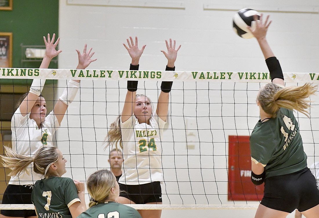 Seniors Ava Egolf (L) and Ava Smith of Tippecanoe Valley go up to block the kill attempt of Wawasee's Danika Miller.