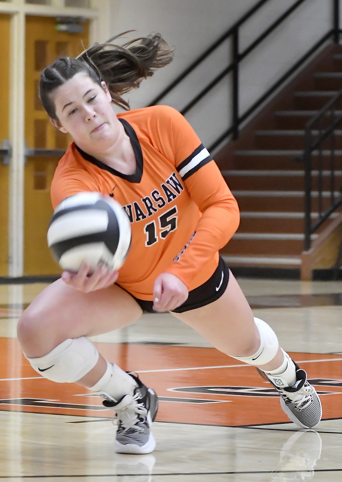 Warsaw junior Maggie Hollon makes a diving dig to keep the ball in play during the second game of Thursday night's home match against Huntington North. Photo by Gary Nieter