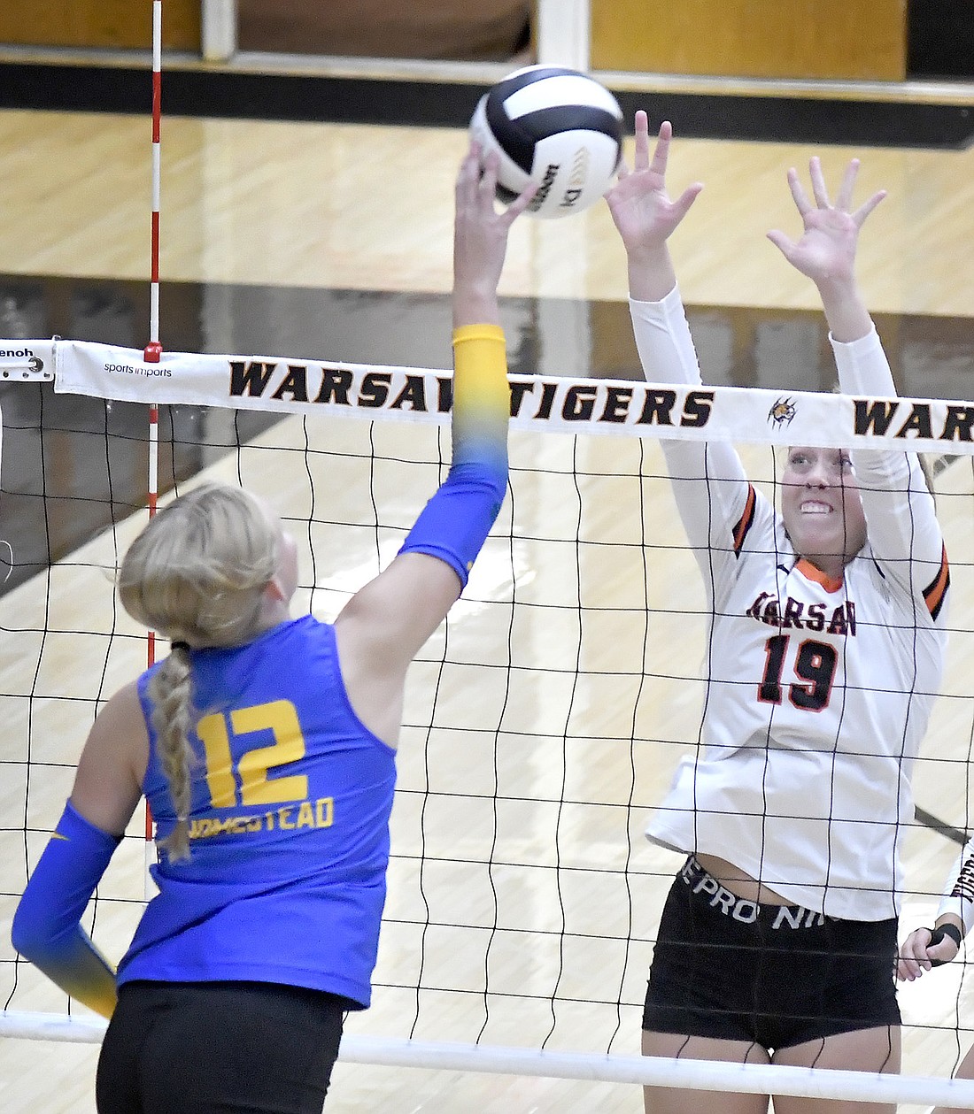 Warsaw junior Krista Lauck goes up for a block against Taeley Mahler of Homestead during the second set. Photo by Gary Nieter