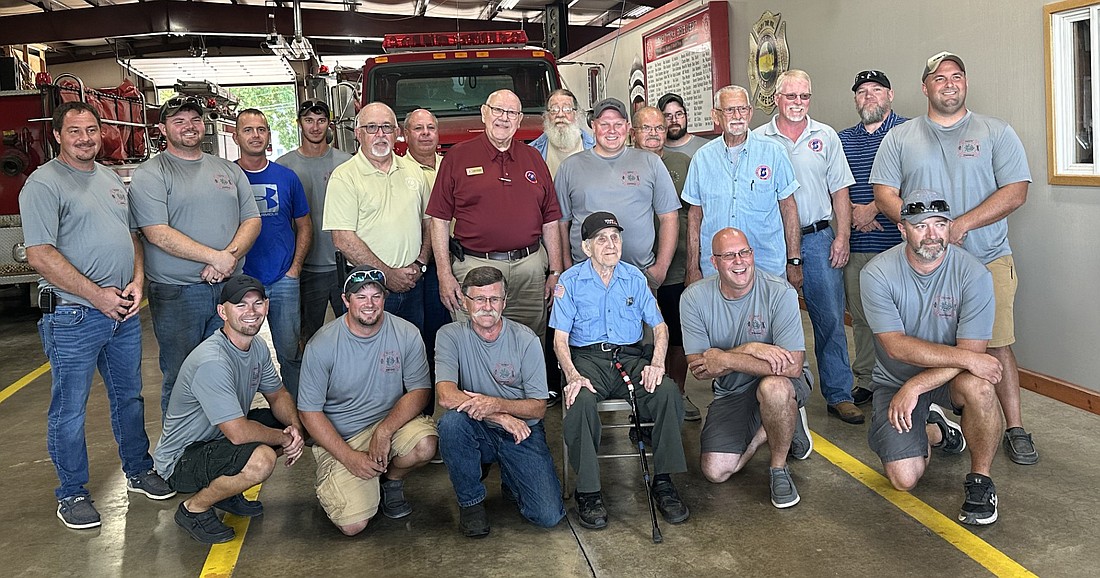 Ray Doering (seated, C), 101, poses with his fellow firefighters from the Henry Township Fire Department in Akron Monday, along with representatives of the Indiana Volunteer Firefighters Association. Photo by David Slone, Times-Union