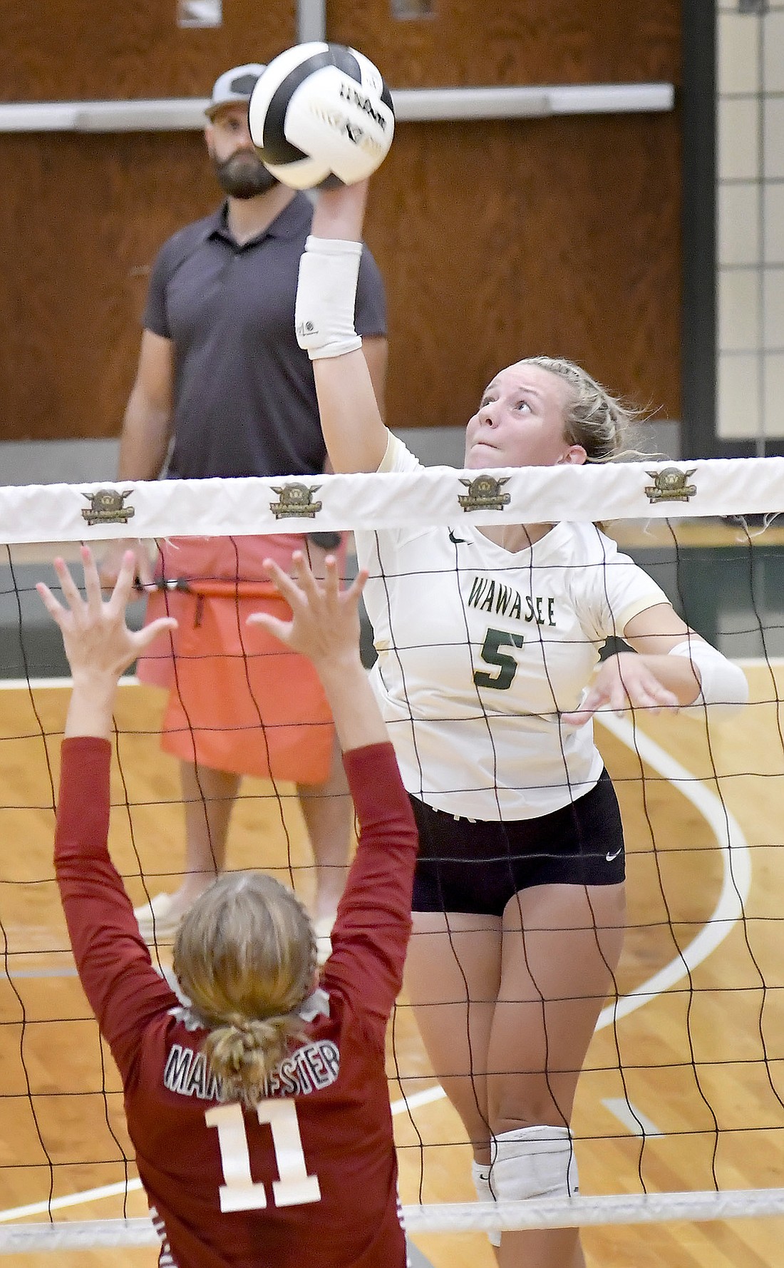 Wawasee senior Ally McClintic elevates for a kill as Manchester's Peyton Ream defends during Wawasee's home match Tuesday night. Photo by Gary Nieter