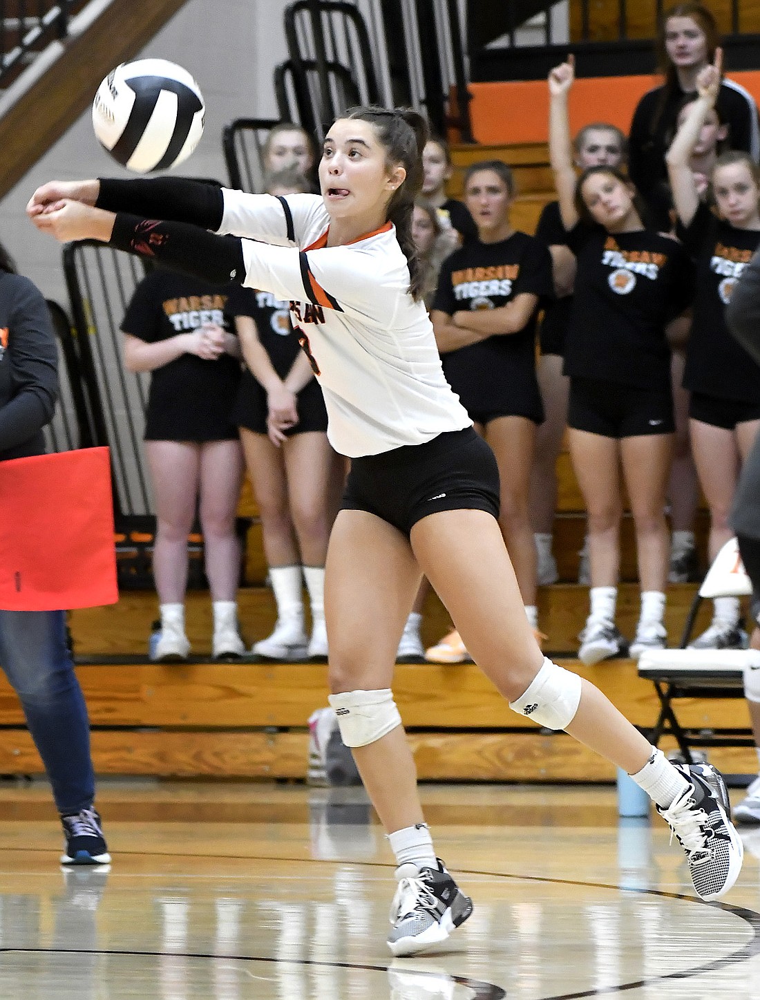 Sophomore Ellie Hepler of Warsaw reaches back to keep the ball in play during the first set. Photo by Gary Nieter