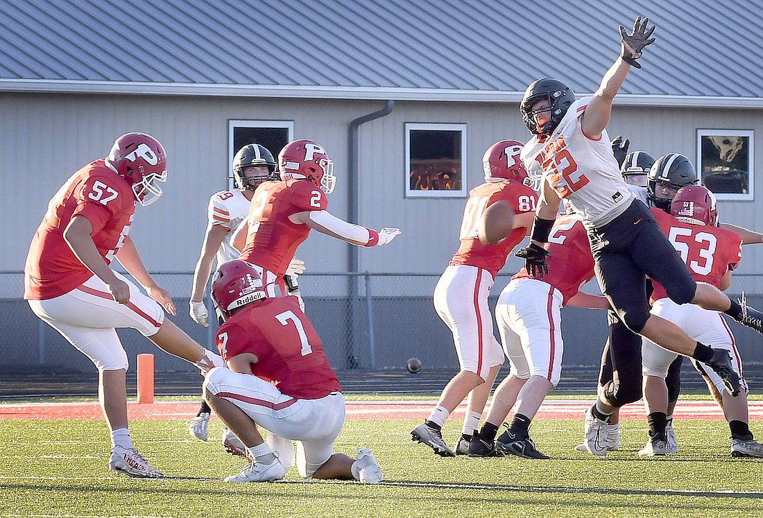 Senior Eric Pohl of Warsaw breaks though the Plymouth line to block the field goal attempt of Carlos Carrillo during Friday night's game at Plymouth. Photo by Gary Nieter