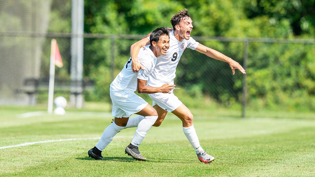 Grace’s Martim Sequeira (right) hugs a teammate during the Lancers’ win over Missouri Valley.