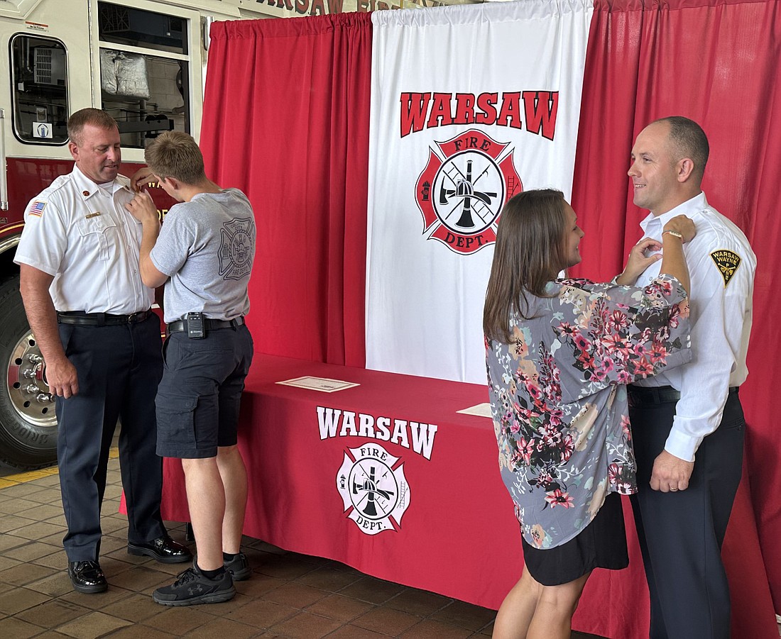 Warsaw-Wayne Fire Territory Battalion Chief Nate Iden (L) has his badge pinned onto his uniform by his son, Colyn Iden, while Battalion Chief Shade Keeney (R) has his badge pinned onto his uniform by his wife, Ashley Keeney. Photo by David Slone, Times-Union