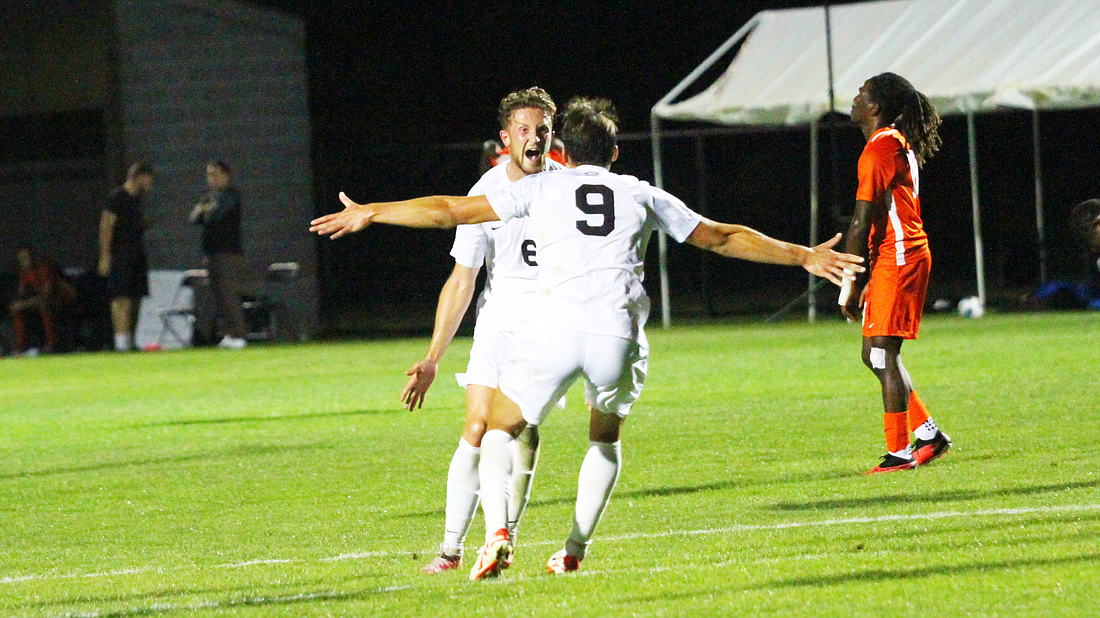 A pair of Grace Lancers celebrate a goal by Dan Allen in Grace’s 1-0 win over Indiana Tech.