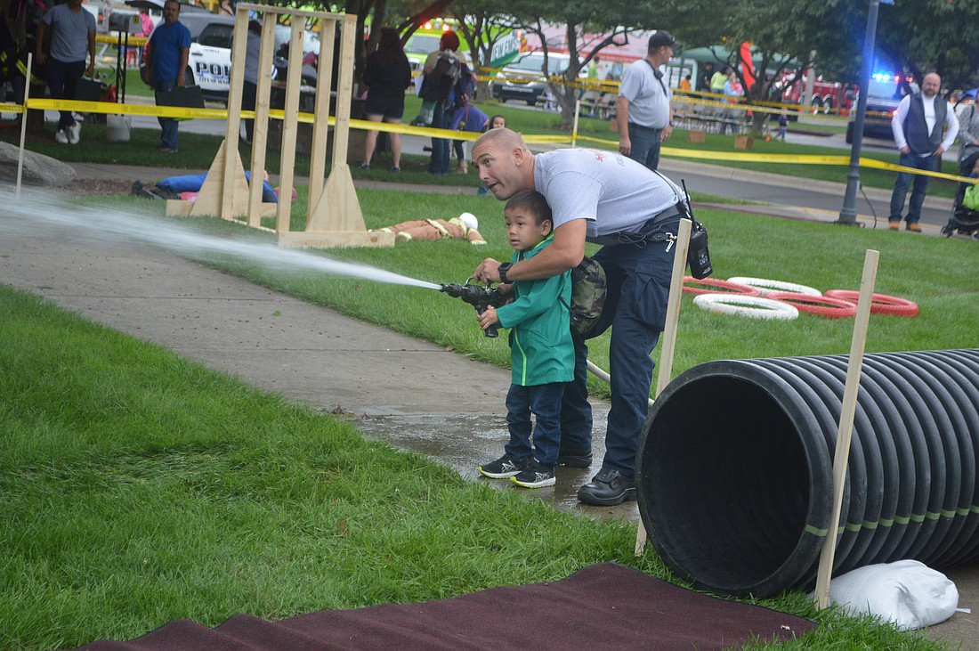 An unidentified kid enjoys the Warsaw-Wayne Fire Territory’s Junior Firefighter Challenge during the 2018 Family Safety Day in Central Park, Warsaw. After a four-year hiatus, the free Family Safety Day returns this Saturday. Photo by David Slone, Times-Union