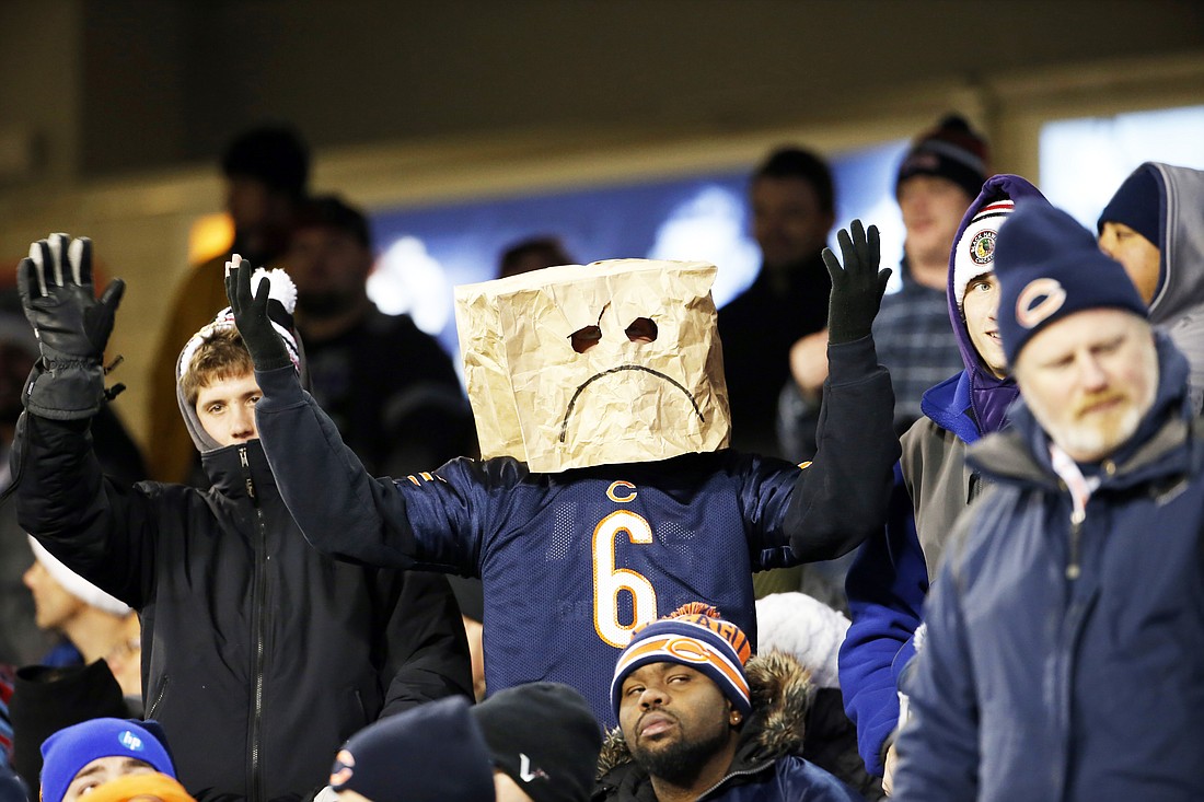 A Chicago Bears fan wears a paper bag on his head during the second half of an NFL football game against the Dallas Cowboys Thursday, Dec. 4, 2014, in Chicago. (AP Photo/Charles Rex Arbogast)