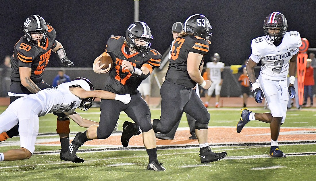 Warsaw senior Reed Zolinger shakes off a would-be NorthWood tackler for a long gain en route to running for 313 yards for the night. Photo by Gary Nieter