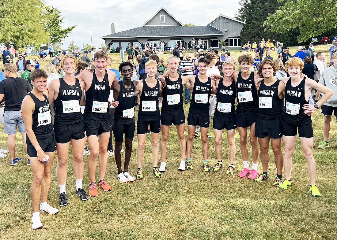 The Warsaw boys cross country team celebrates after a third place finish at the Flashrock Invite on Saturday.