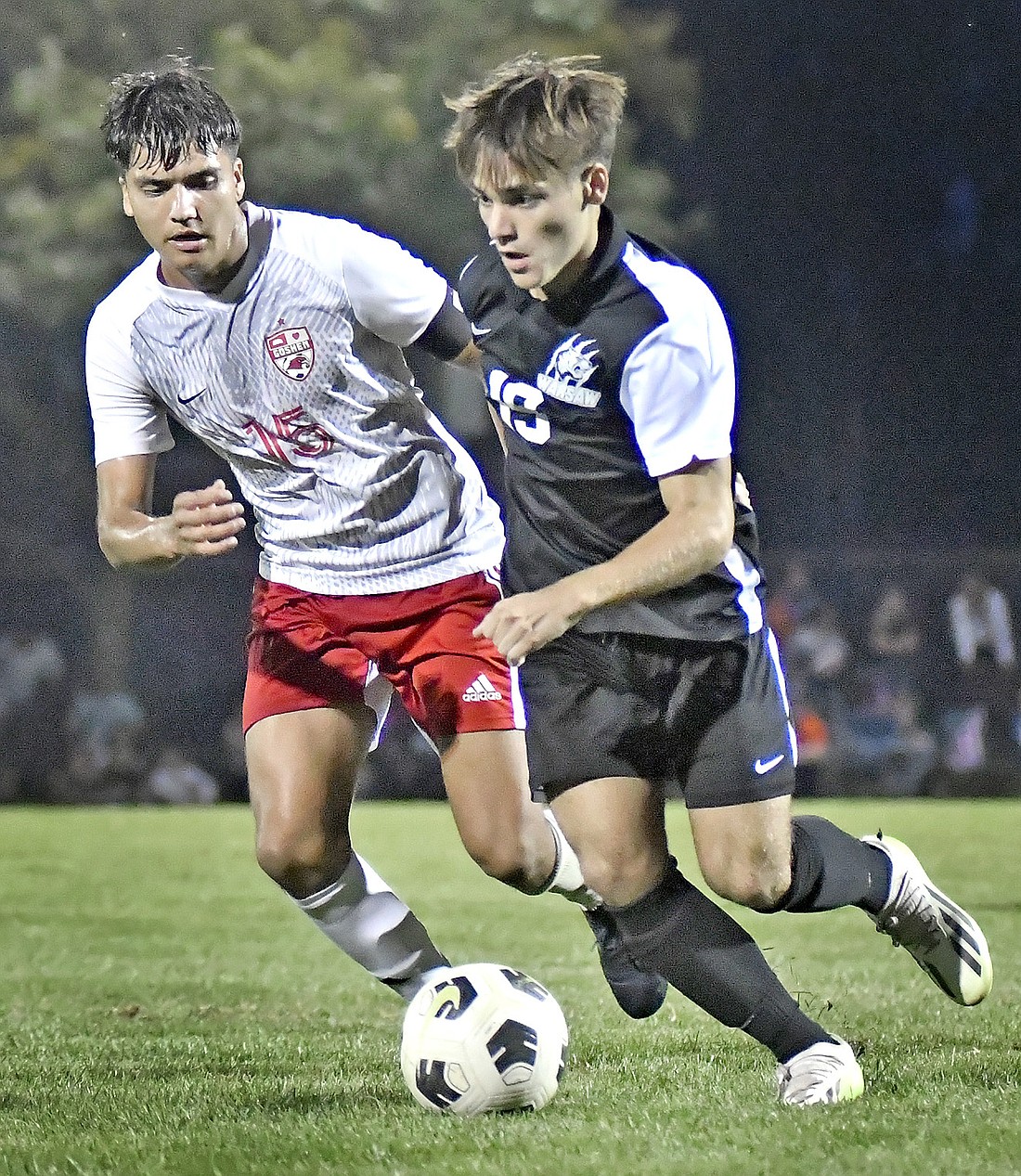 Junior Ashton Ault of Warsaw turns the ball upfield as Goshen's Cesar Vela defends during Thursday night's match at Warsaw. Photo by Gary Nieter