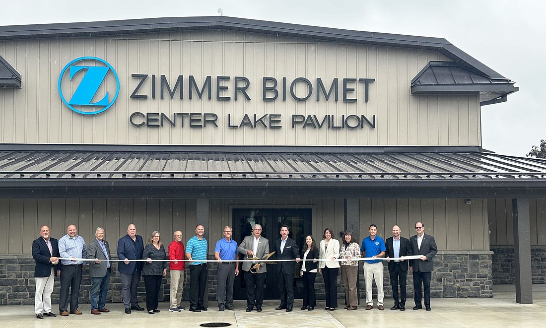 Taking part in the ribbon-cutting for the Zimmer Biomet Center Lake Pavilion are (L to R) Scott Wiley, Kosciusko Chamber of Commerce; Aaron Ott, Warsaw city engineer; Jack Wilhite, Warsaw City Council; Jim Lancaster, Zimmer Biomet; Tabatha McDonald, Zimmer Biomet; Larry Ladd, Warsaw Parks Board; Shaun Gardner, Warsaw Parks and Recreation Department; Larry Plummer, Warsaw Parks and Recreation Department; Warsaw Mayor Joe Thallemer; Zimmer Biomet CEO and President Ivan Tornos; Rachel Ellingson, Zimmer Biomet; Keri Mattox, Zimmer Biomet; Diane Quance, Warsaw City Council; Jed Frauhiger, Zimmer Biomet; Adam Griner, Zimmer Biomet; and Dr. Jeffrey Fawcett, Kosciusko Chamber of Commerce. Photo by David Slone, Times-Union.