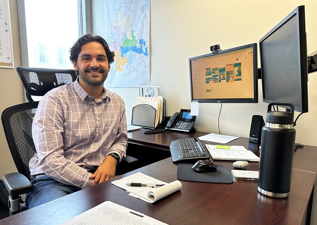 Warsaw Assistant City Planner Jackson Longenbaugh poses for a photo at his desk at City Hall. Photo by David Slone, Times-Union