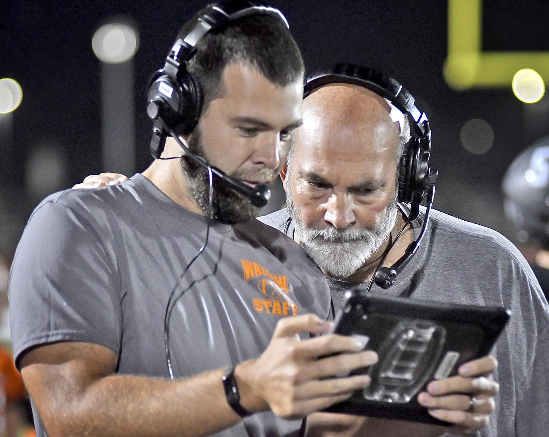 Assistant Warsaw coach Michael Curtis and his dad, head coach Bart Curtis, have a meeting of the minds while reviewing game action. Photo by Gary Nieter