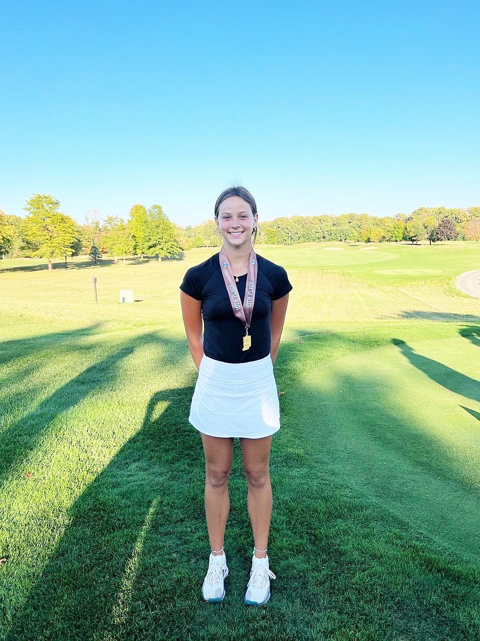 Warsaw's Abbey Peterson shows off her newest medal after her top 10 finish at the IHSAA girls golf state finals.