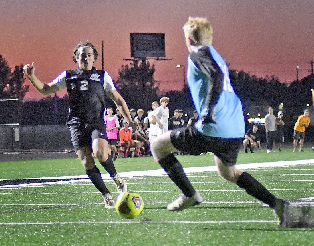 Senior Matthew Marsh of Warsaw races to the ball as Columbia City goalie Jacob Mullett moves in to defend. Photo by Gary Nieter