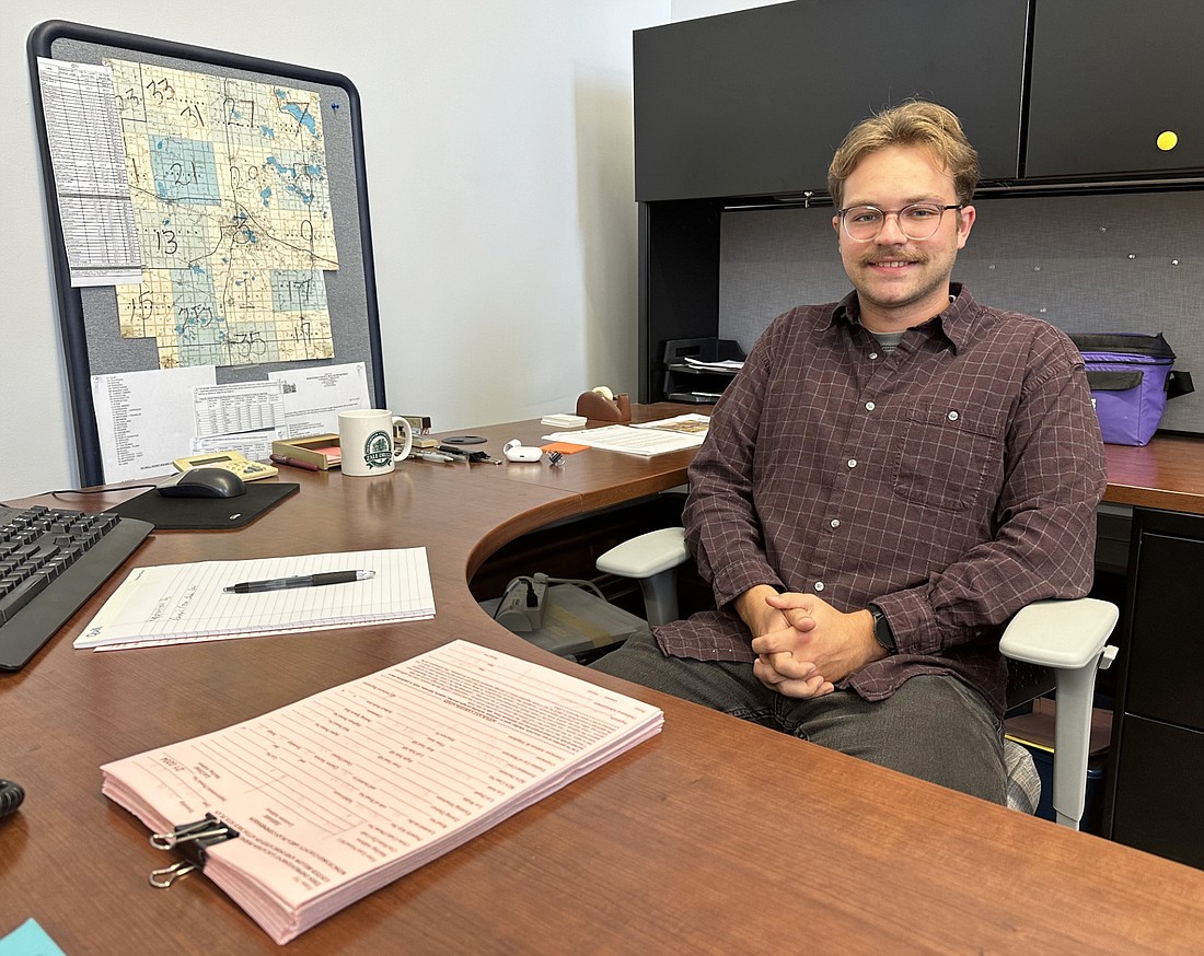 Kosciusko County Area Plan Assistant Planner Andy Heltzel poses for a photo at his desk Tuesday. Photo by David Slone, Times-Union