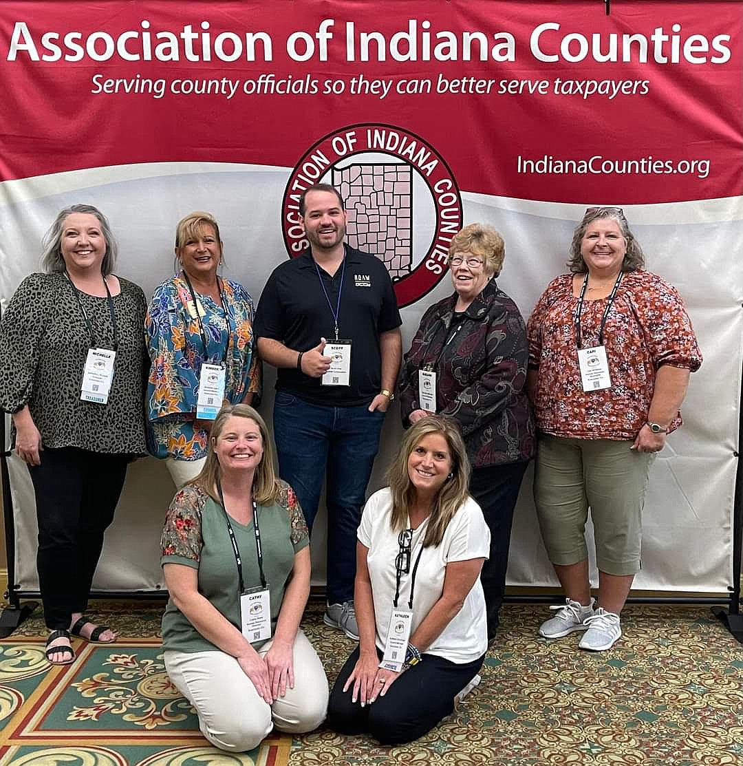 Attending the Association of Indiana Counties Annual Conference from Kosciusko County were (L to R), front, kneeling: Human Resource Director Cathy Reed and Council Member Kathy Groninger; back row: Treasurer Michelle Puckett, Council member Kimberly Cates; Scott Clay, Kosciusko County resident representing RQAW Vendor in attendance at the conference; Council member Sue Ann Mitchell and Assistant HR Director Cari Williams. Photo Provided.