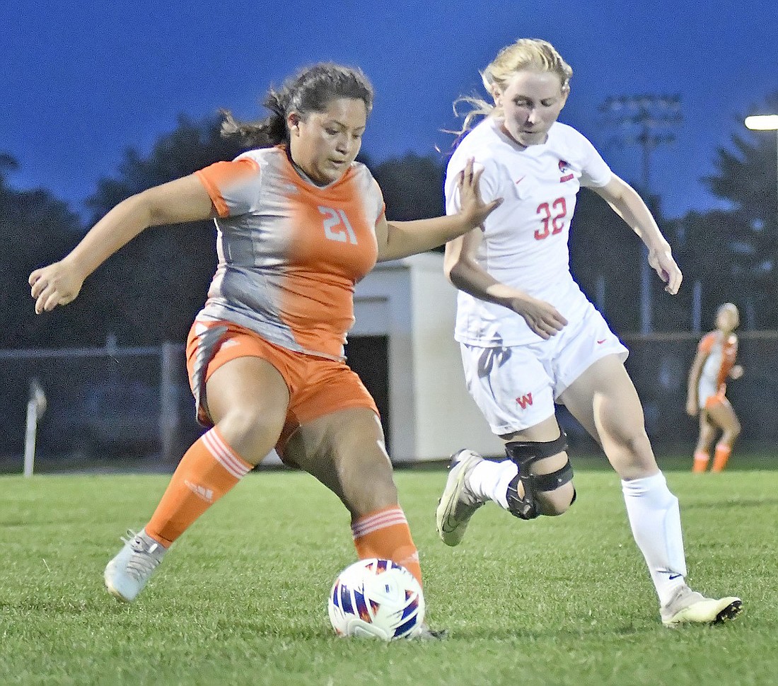 Nury Sibri Carmona (L) of Fort Wayne Northrop tries to put distance between herself and Warsaw senior Sophia Johnston during the first half. Photo by Gary Nieter