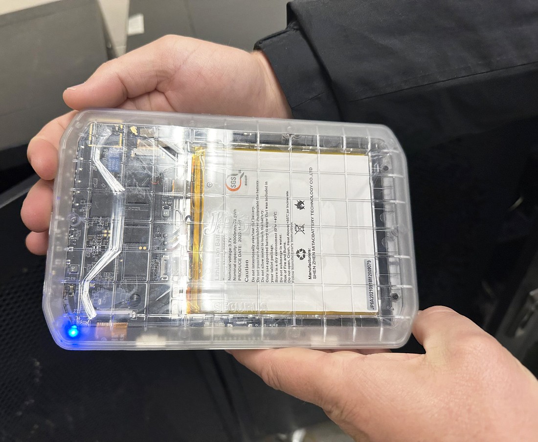 Kosciusko County Jail Commander Sgt. Kevin Gelbaugh holds one of the tablets being used in the jail upside down to display the inner workings of it. By the case being clear, a person can tell whether the tablet has been tampered with or not. Photo by David Slone, Times-Union.