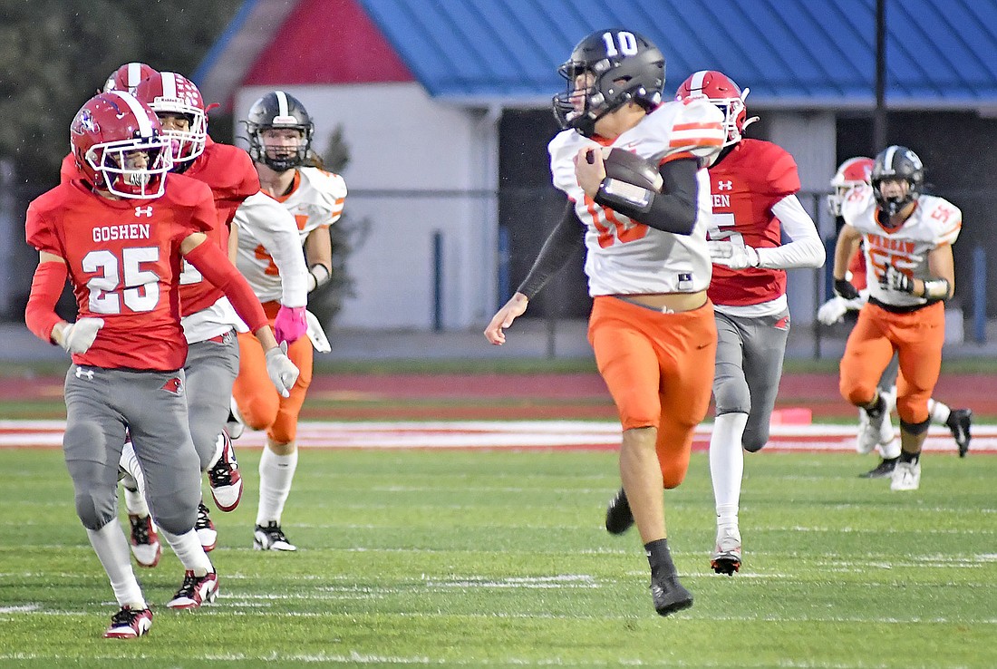 Sophomore quarterback Quinton Brock takes a glance back while running away from the Goshen defense for Warsaw's second touchdown Friday night at Goshen. Photo by Gary Nieter