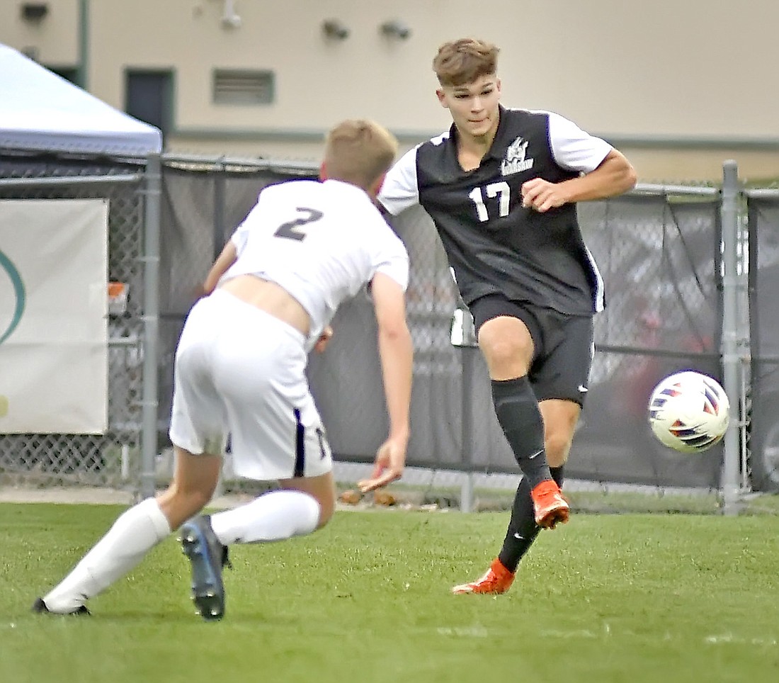 Senior Rylan Smith of Warsaw passes off to a teammate during the first half. Photo by Gary Nieter