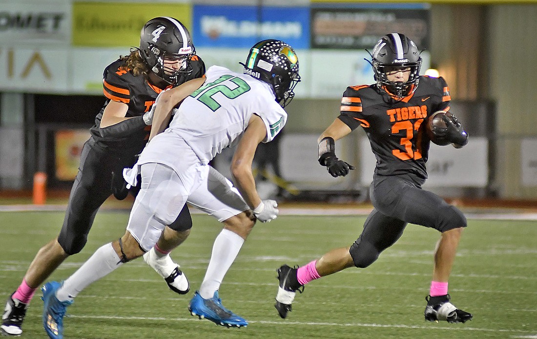 Warsaw senior Lucas Ransbottom picks up a block from junior teammate Ethan Egolf during the second quarter. Photo by Gary Nieter