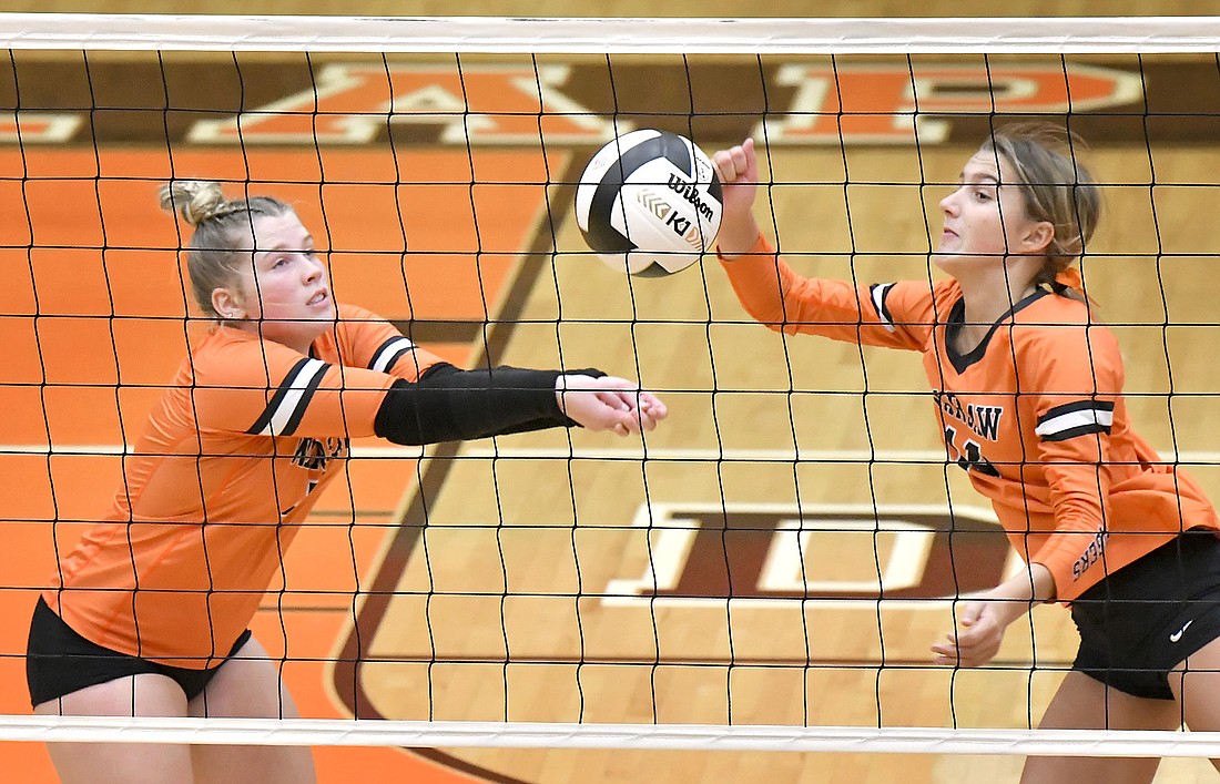 Warsaw senior Claire Reichenbach (L) and sophomore Avary Hoeppner make a play on the ball during the fourth set. Photo by Gary Nieter