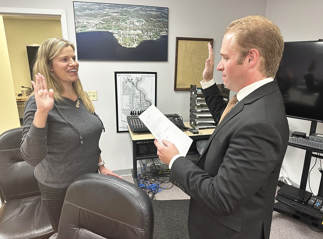 Heather James (L) takes the oath of office as the new Winona Lake clerk-treasurer, given to her by Kosciusko County Republican Central Committee Secretary Austin Rovenstine (R). Photo by David Slone, Times-Union