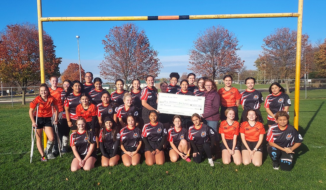 The Warsaw Community High School girls rugby team donated $1,000 to Big Brothers Big Sisters Thursday. Pictured are the members of the rugby team and Tammy Smith, community development director for BBBS. Photo by Jackie Gorski, Times-Union