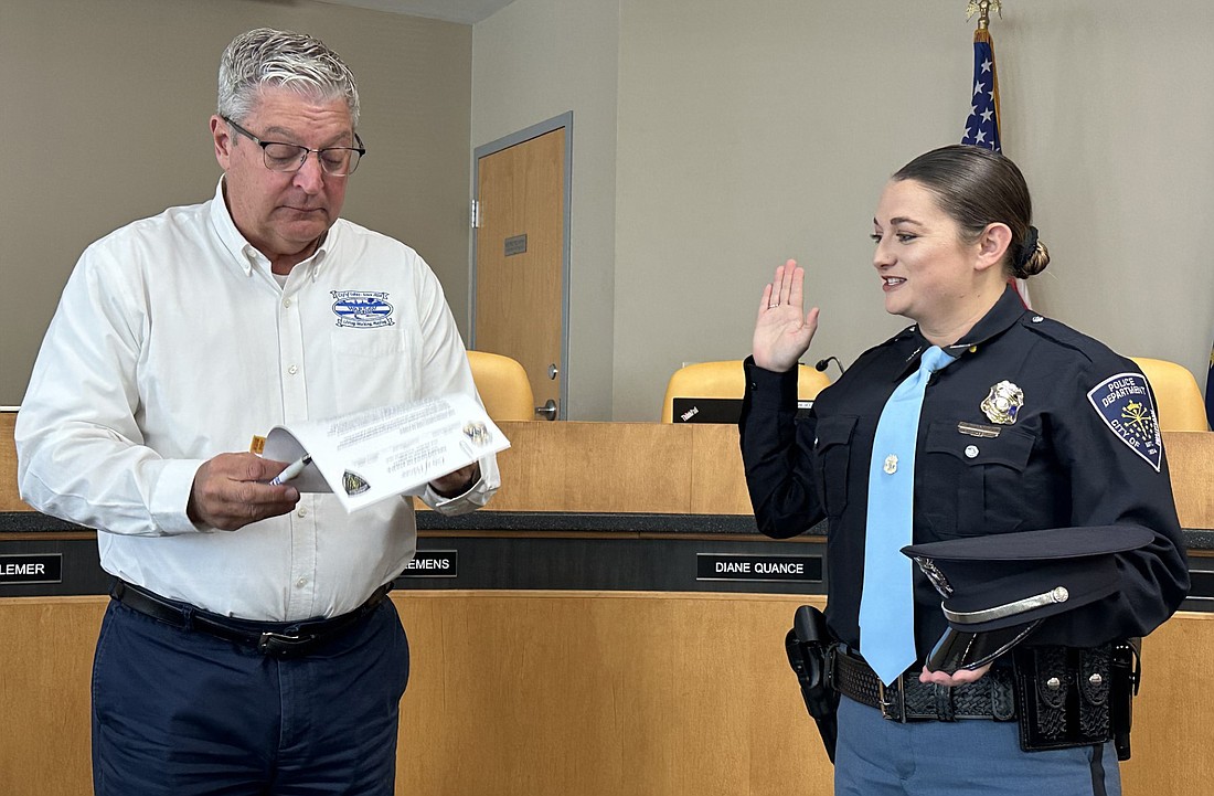 Warsaw Mayor Joe Thallemer (L) gives the ceremonial oath of office to Warsaw Police Department officer Danielle M. Kirkdorffer (R). Photo by David Slone, Times-Union