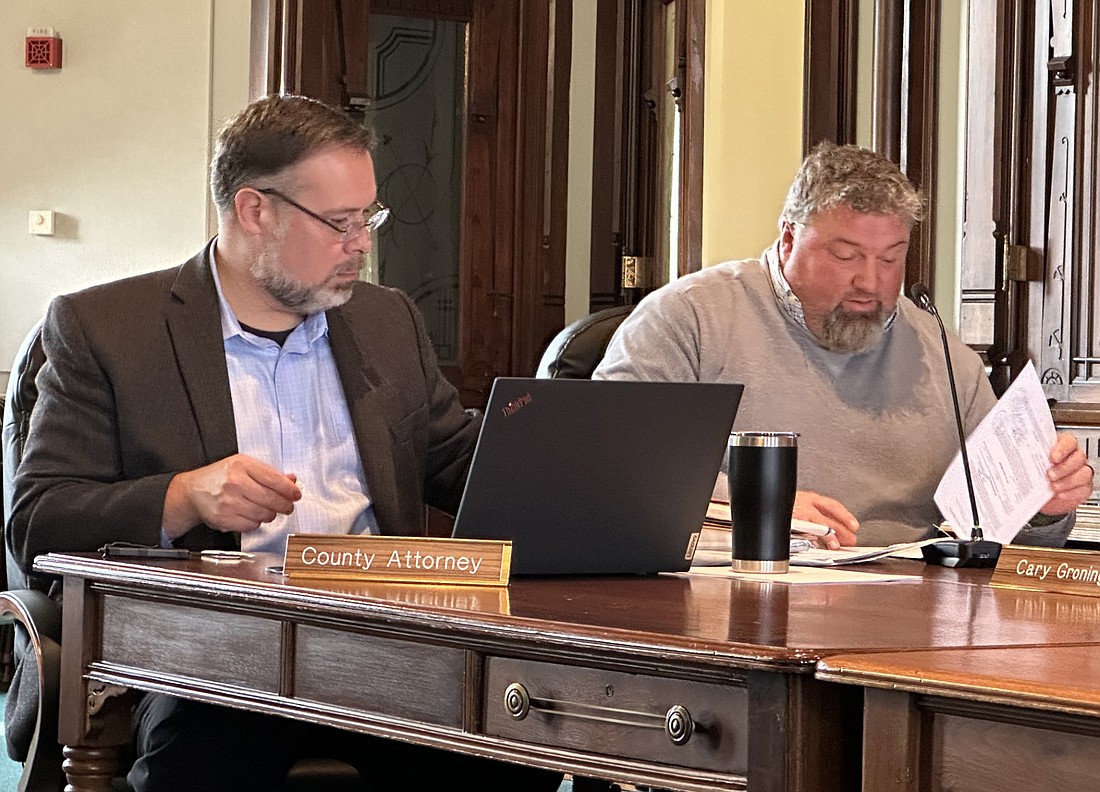Kosciusko County attorney Ed Ormsby (L) and Kosciusko County Highway Department Superintendent Steve Moriarty (R) open the bids for materials for the KCHD’s use in 2024. Photo by David Slone, Times-Union