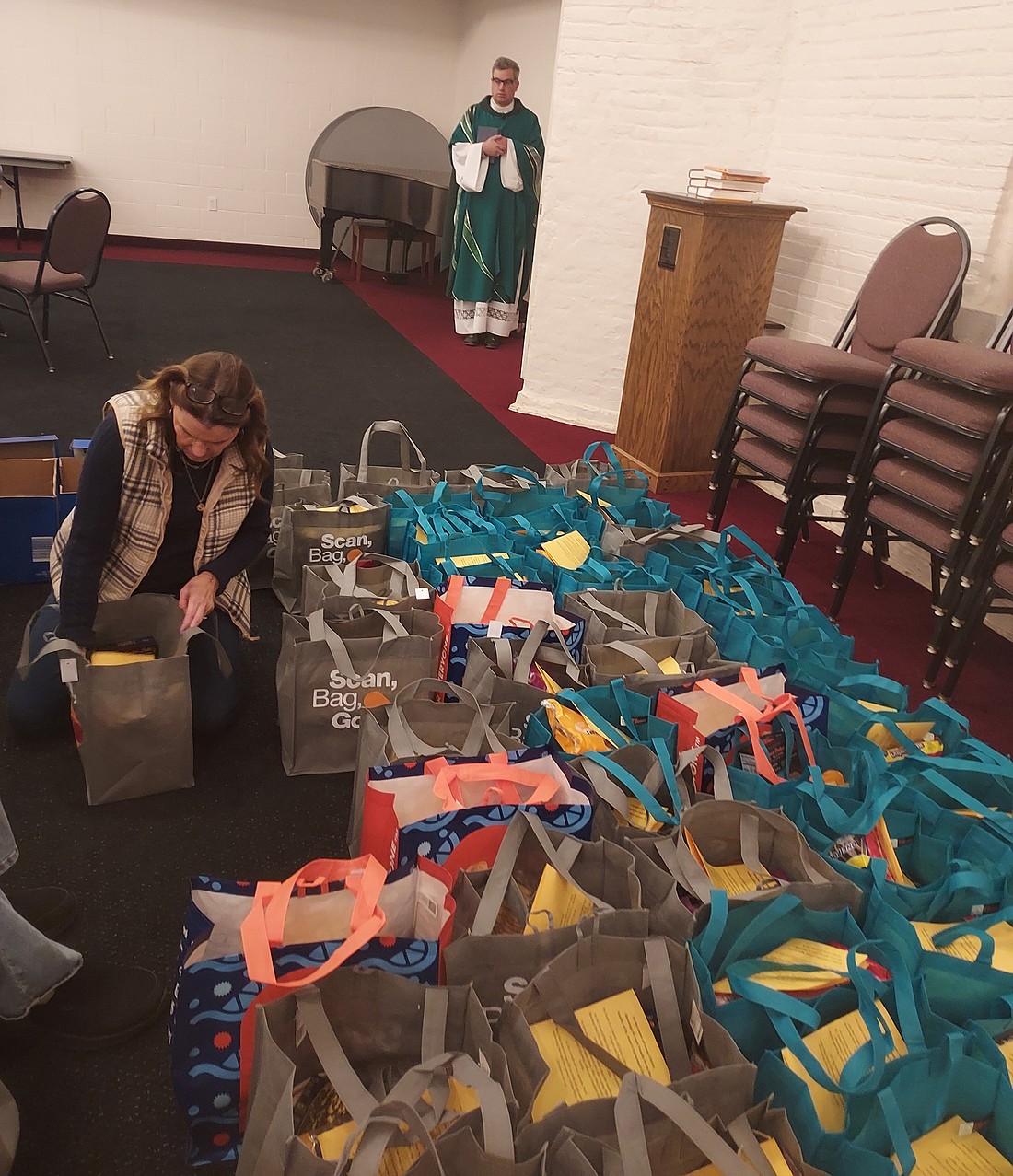 Cathy Carter examines Thanksgiving baskets before they are given out Sunday. Photo by Jackie Gorski, Times-Union