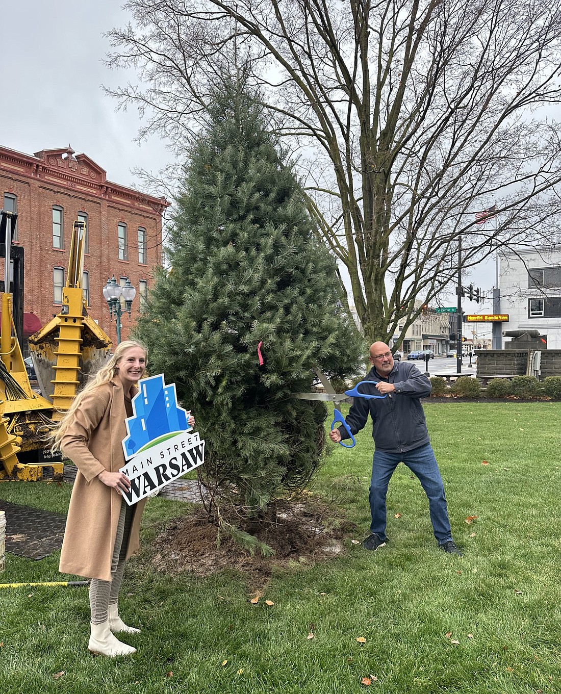 Main Street Warsaw Events Coordinator Mackenzie Parker (L) and Member Relations Manager Scott Wiley celebrate the planting of the concolor fir tree on the southeast lawn of the Kosciusko County courthouse Tuesday. Wiley said Main Street Warsaw donated the tree to the county. Photo by David Slone, Times-Union