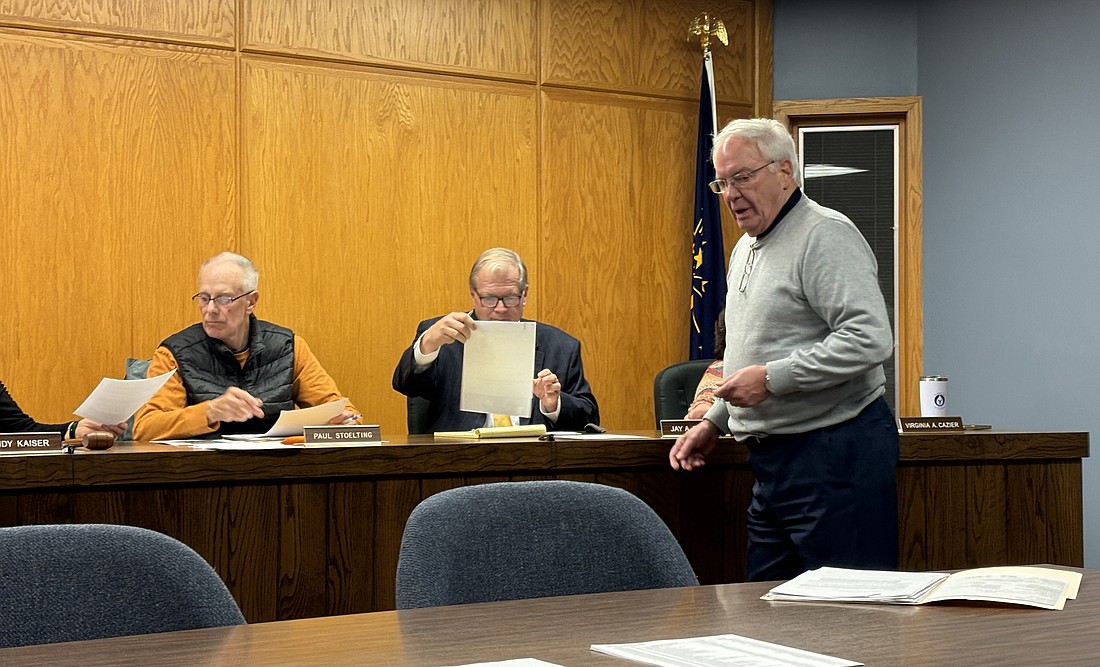 Attorney Steve Snyder (standing) passes some paperwork to the Syracuse Town Council members Tuesday evening. Seated (L to R) are Councilman Paul Stoelting and town attorney Jay Rigdon. Photo by Denise Fedorow.