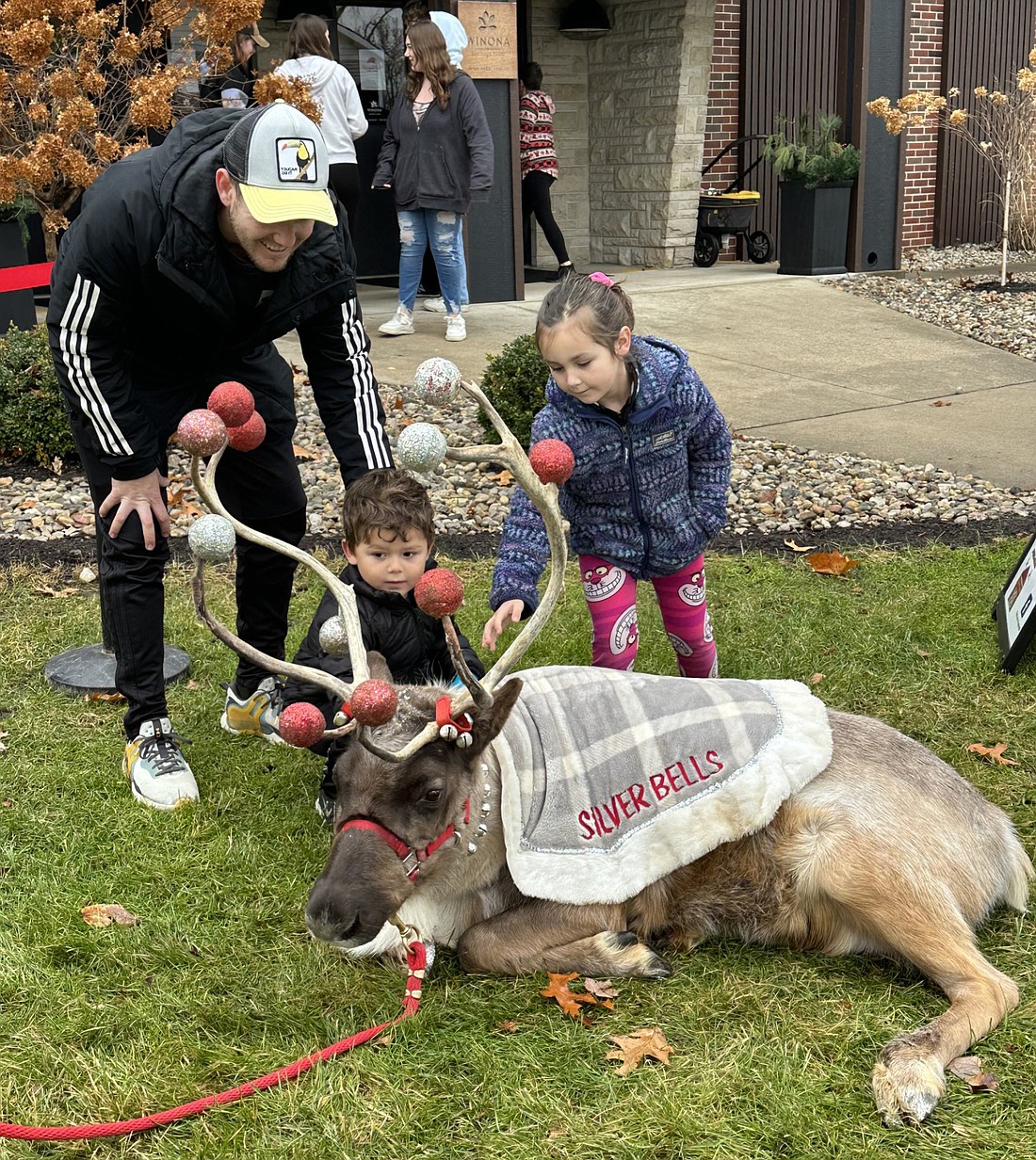 Jake Crone (L) and his two children, Gideon and Amelia, check out Silver Bells from Animal-Grams during Kringle Fest in Winona Lake on Saturday. Photo by David Slone, Times-Union