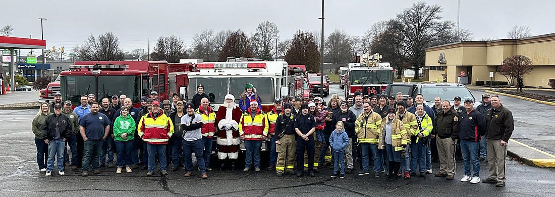 Firefighters from across Kosciusko County, as well as the sheriff and officers from the sheriff’s office, and some of their family members, pose for a group photo at JB’s Furniture in Warsaw Saturday before delivering the toys they collected and purchased to the Toys for Tots toy drive at Martin’s Super Market. Photo by David Slone, Times-Union