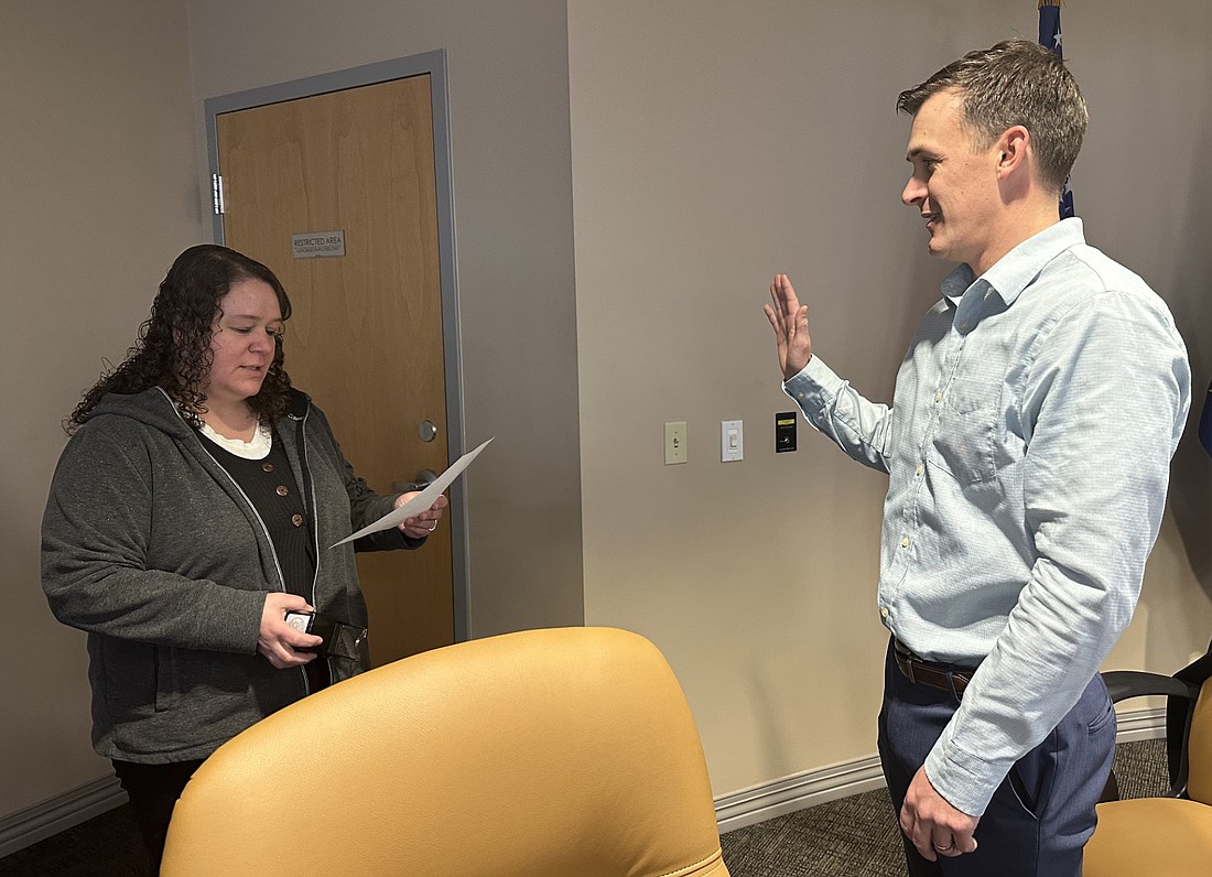 Notary Public Amanda Clabaugh (L) gives Chris Hanson (R) the oath of office before the Warsaw Building Corporation meeting Tuesday. Photo by David Slone, Times-Union