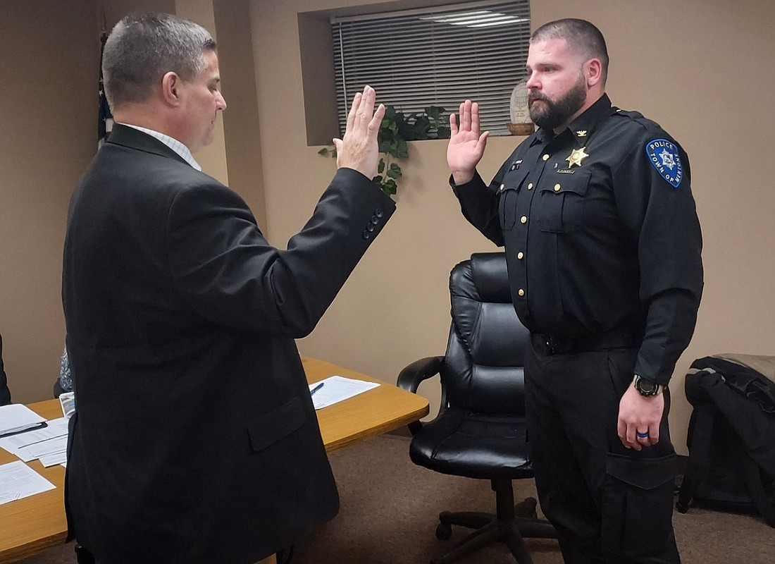 Mentone town attorney Andrew Grossnickle (L) gives Keaton Schopf the oath of office for town marshal Wednesday. Photo by Jackie Gorski, Times-Union
