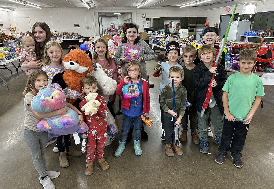 A group of children pose with some of the gently used toys that are part of the Combined Community Services Toy Time consignment sale and giveaway. Photo by David Slone, Times-Union