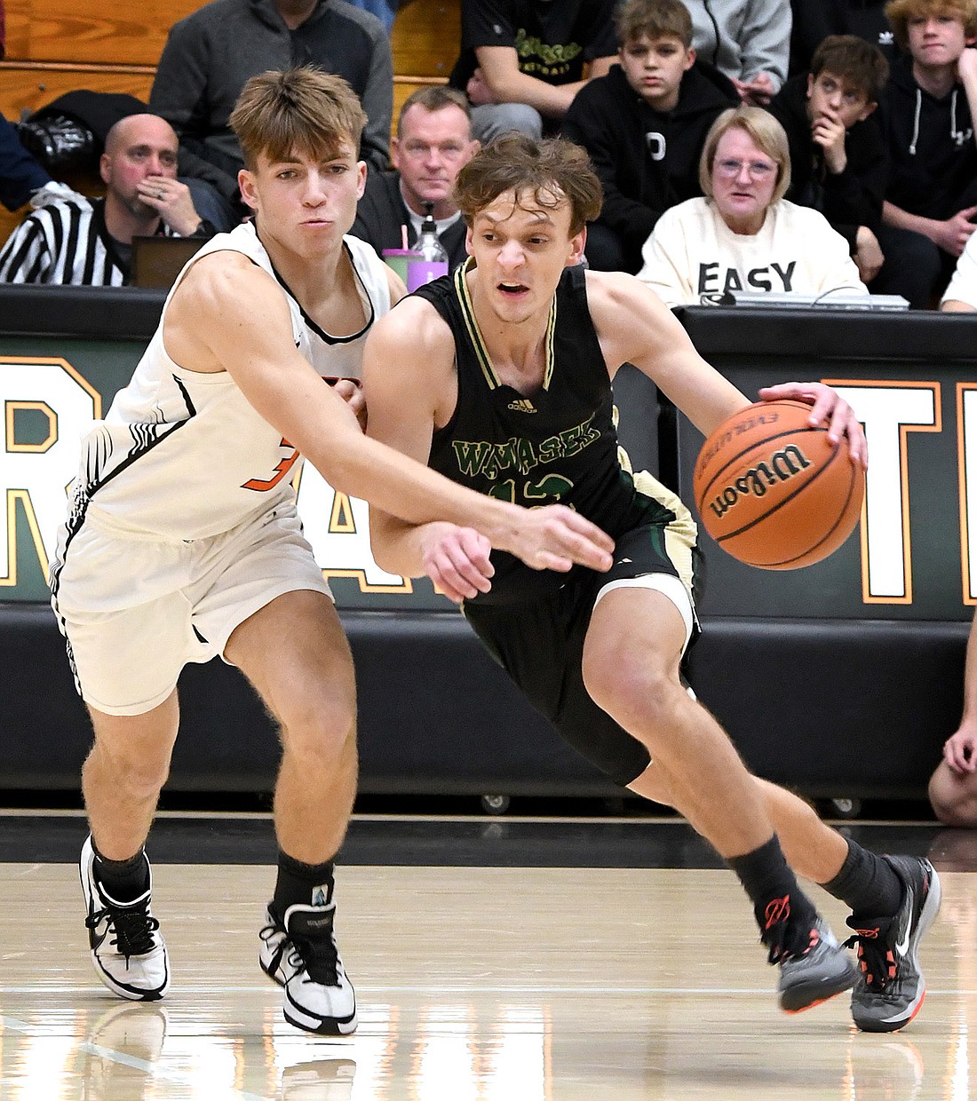 Junior Myles Everingham of Wawasee drives the ball upcourt as Warsaw's Tristan Wilson defends. Photo by Gary Nieter