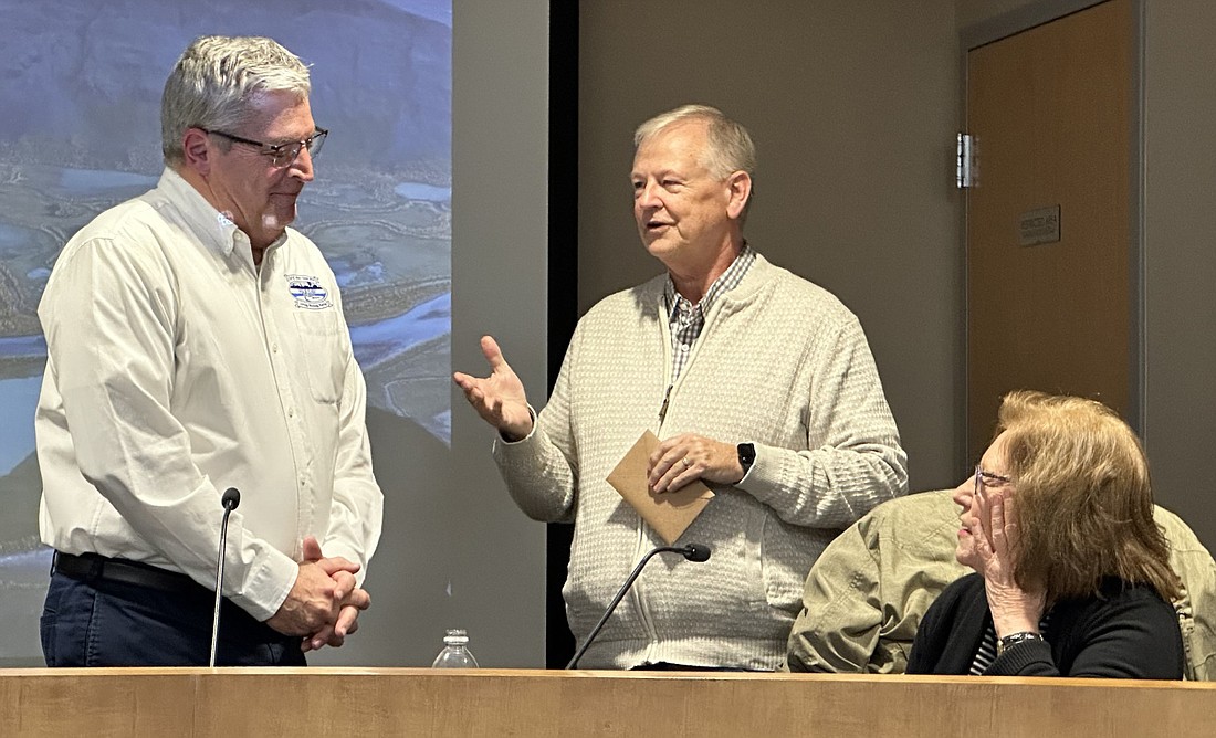 Warsaw Common Council President Jack Wilhite (standing, R) presents retiring Mayor Joe Thallemer (L) with a gift from the council in appreciation for his service to the city. Sitting is Councilwoman Cindy Dobbins. Photo by David Slone, Times-Union