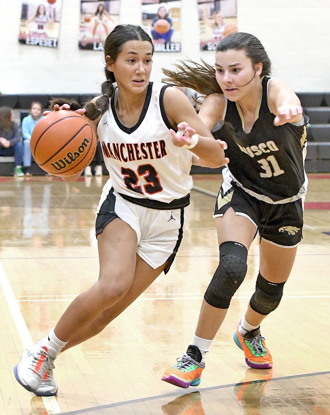 Manchester sophomore Hadley West drives to the basket during the second quarter as Churubusco's Jessica Price defends. Photo by Gary Nieter