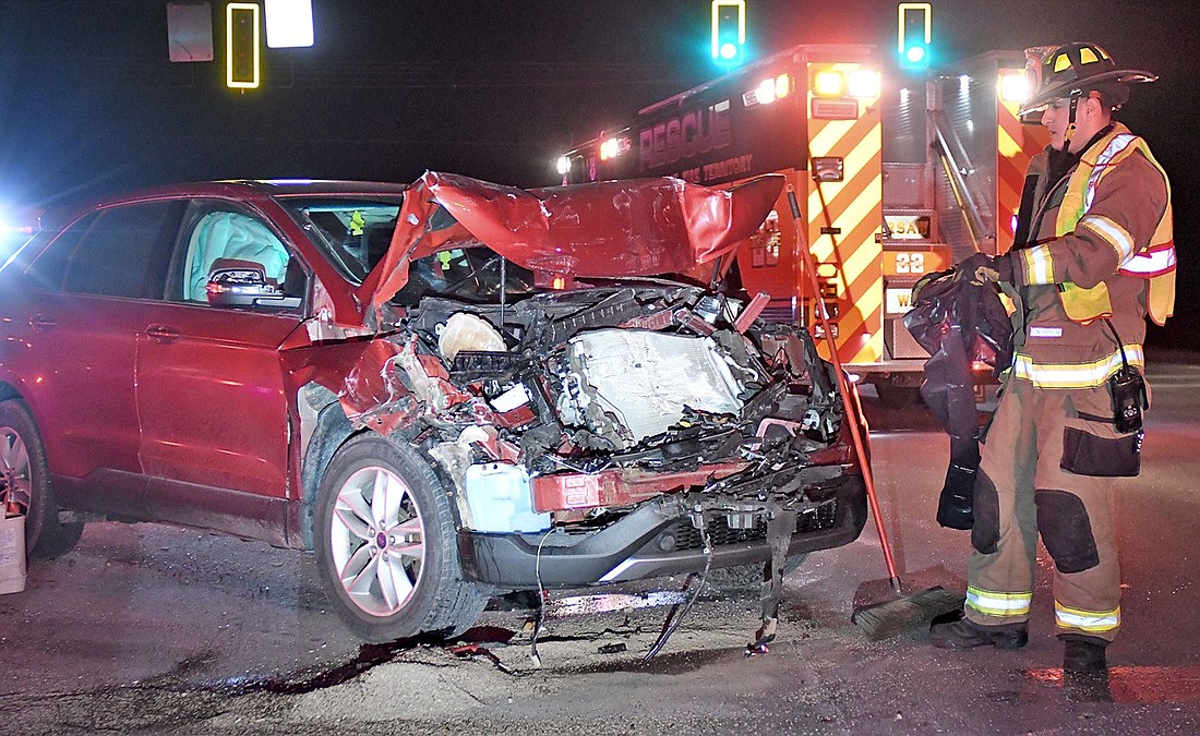 A Warsaw firefighter works on cleanup after Saturday's early morning two-vehicle collision in the eastbound lane of U.S. 30 at CR 150W. Photo by Gary Nieter, Times-Union