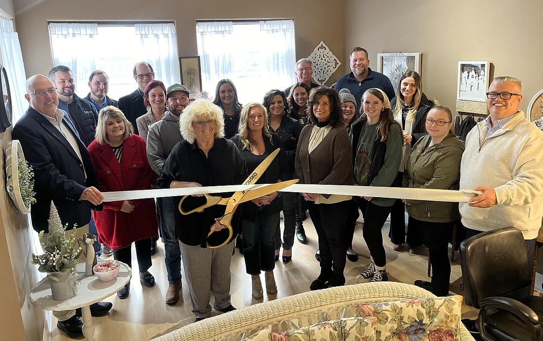 Jacque Bradley (C, with scissors) cuts the ribbon for Bailey’s Studio, 25 Kings Hwy., Winona Lake, during the ribbon-cutting ceremony Thursday with the Kosciusko Chamber of Commerce. Photo by David Slone, Times-Union