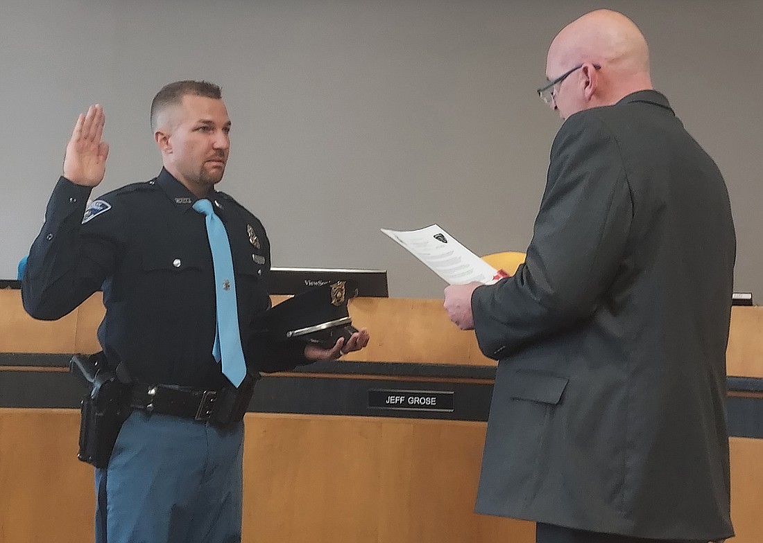 Warsaw Mayor Jeff Grose (R) gives Drew Brewton his oath of office for the Warsaw Police Department Friday. Photo by Jackie Gorski, Times-Union